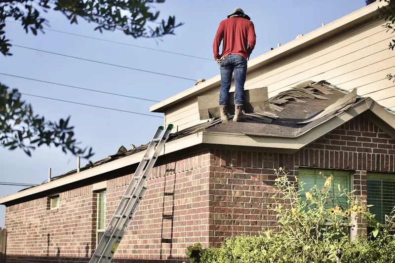 Professional roofer working on a residential roof in Toland